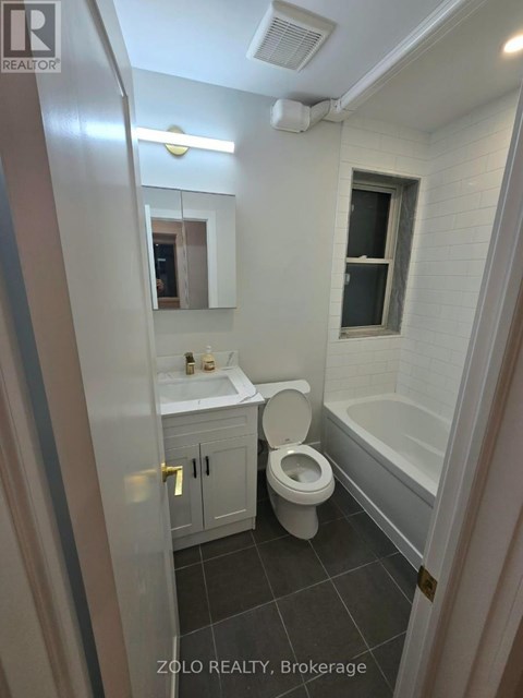 A bathroom with a toilet, sink, and bathtub.