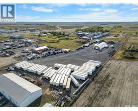 An aerial view of a large industrial area with multiple buildings and parked trucks.
