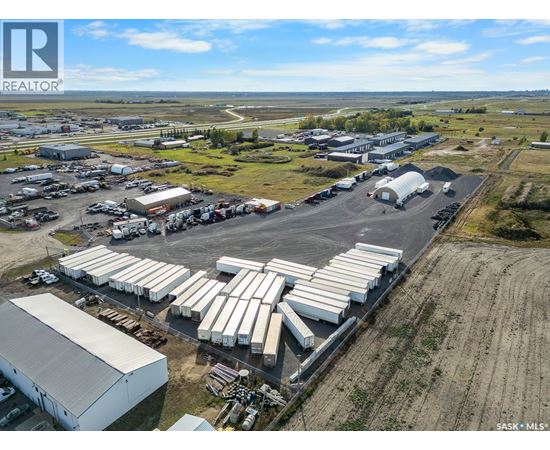 An aerial view of a large industrial area with multiple buildings and parked trucks.