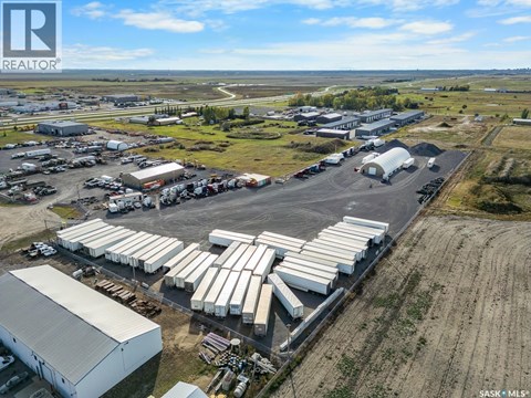 An aerial view of a large industrial area with multiple buildings and parked trucks.
