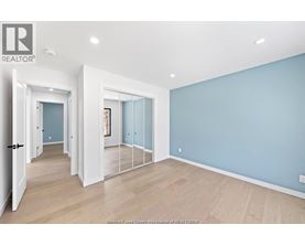 A spacious room with light blue walls and wooden flooring.