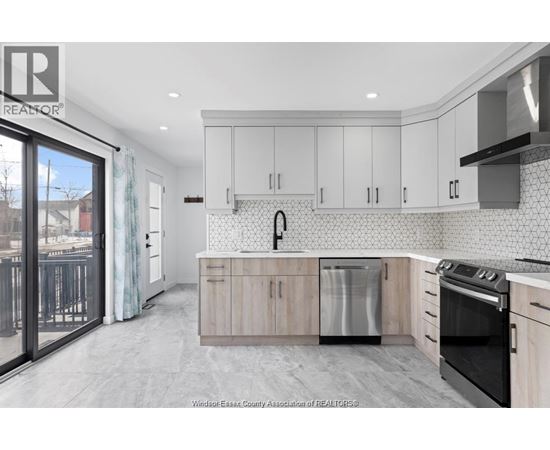 A kitchen with white cabinets and a black stove top oven.