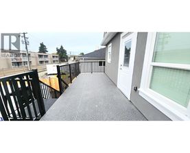 A balcony with a black railing and a grey floor.