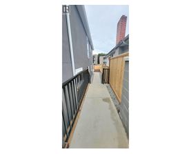 A concrete walkway leads to a building with a red chimney.