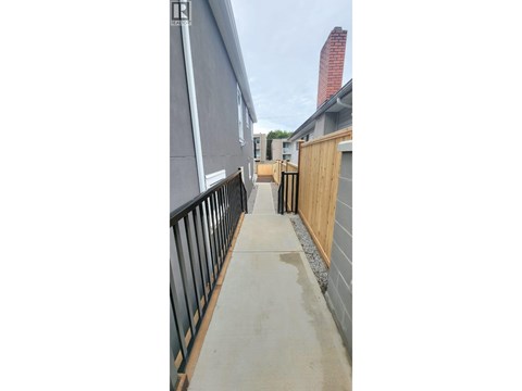 A concrete walkway leads to a building with a red chimney.