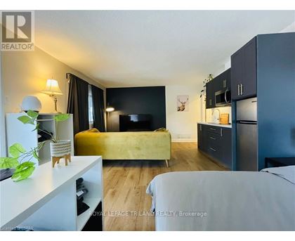 A bedroom with a bed, a couch, and a TV.