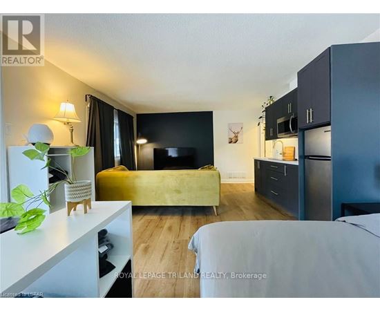 A bedroom with a bed, a couch, and a TV.