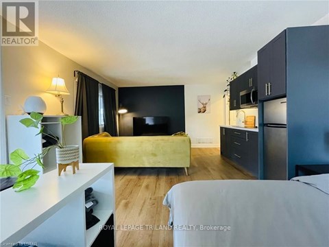 A bedroom with a bed, a couch, and a TV.