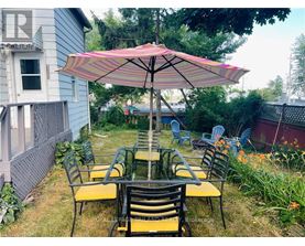 A patio with a table and chairs under an umbrella.