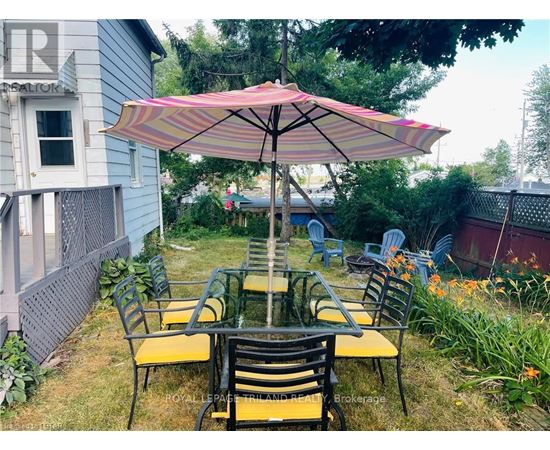 A patio with a table and chairs under an umbrella.