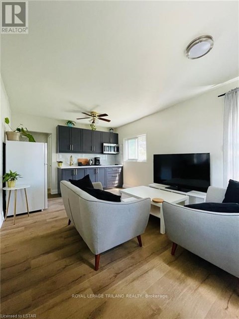 A living room with a grey couch and a black sofa.