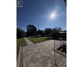 A sunny day with a clear blue sky and a pathway leading to a grassy area.