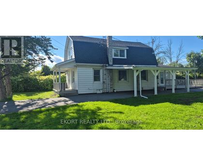 A house with a porch and a sign that says "EKORT REALTY TD Brokerage".