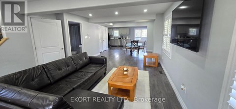 A living room with a black leather couch and a wooden coffee table.