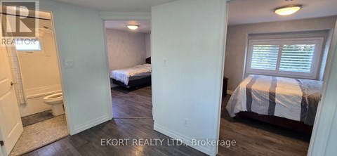 A bedroom with a bed and a window with blinds.