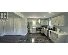 A kitchen with white cabinets and a black floor.