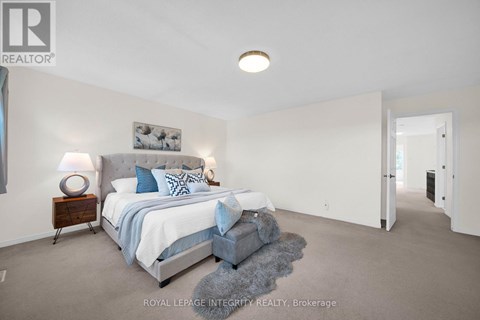 A bedroom with a bed and a nightstand with a lamp.