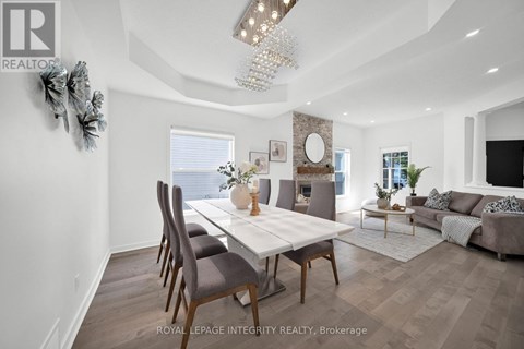 A modern dining room with a white table and chairs.