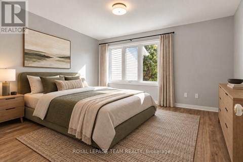 A bedroom with a large bed and a painting on the wall.