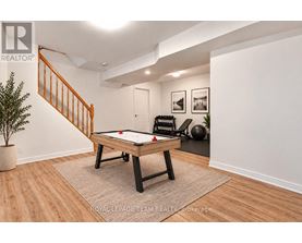 A pool table in a room with a staircase.