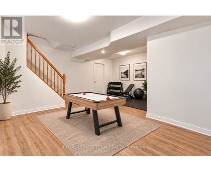 A pool table in a room with a staircase.