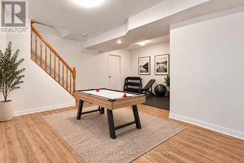 A pool table in a room with a staircase.