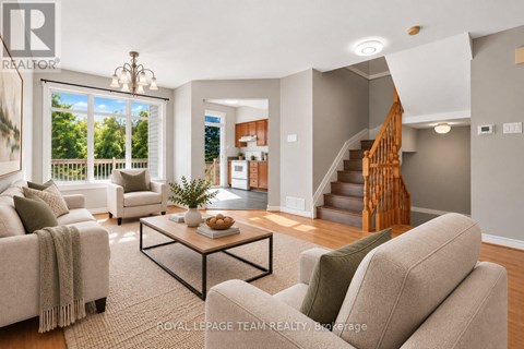 A living room with a couch, coffee table, and staircase.