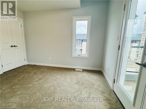 A room with a carpeted floor and a window.