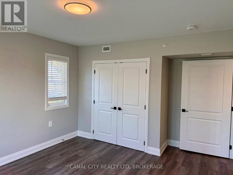 A room with a white door and a window with blinds.
