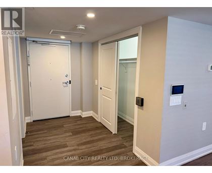 A room with a white door and a glass door leading to a balcony.