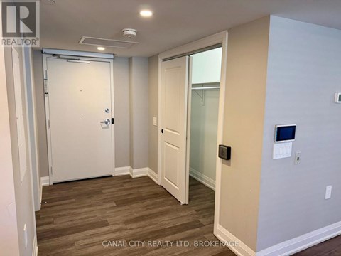 A room with a white door and a glass door leading to a balcony.