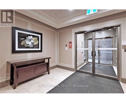 A hallway with a bench and a framed picture of flowers on the wall.
