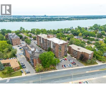 A bird's eye view of a residential area with apartment buildings and cars parked in front.