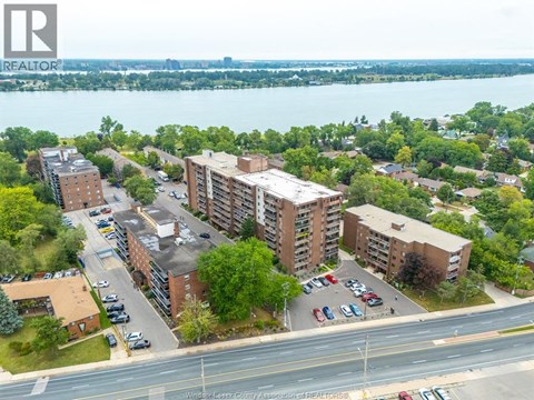 A bird's eye view of a residential area with apartment buildings and cars parked in front.