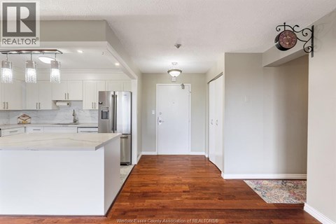 A kitchen with white cabinets and a wooden floor.