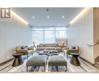 A modern living room with a grey sofa and a glass coffee table.