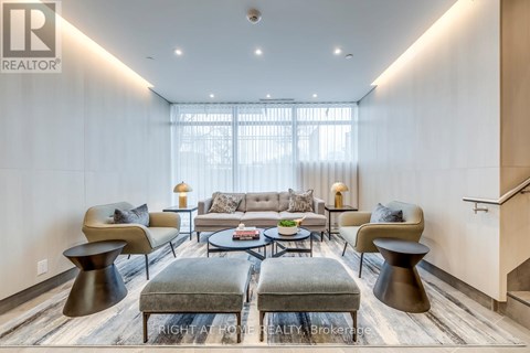 A modern living room with a grey sofa and a glass coffee table.