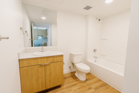 A white bathroom with a toilet, sink, and bathtub.