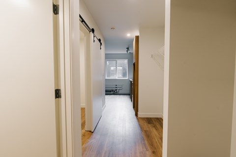 A long hallway with a door on the left and a door on the right.