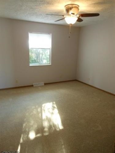 A room with a ceiling fan and a window.