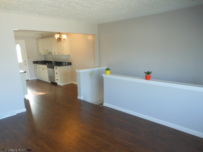 A kitchen with white cabinets and a black counter top.