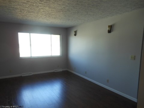A room with a window and a wooden floor.