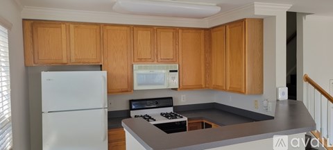 A kitchen with wooden cabinets and a white fridge.