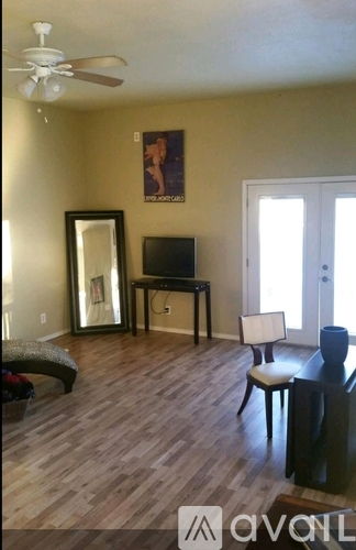 A living room with a wooden floor and a television on a table.
