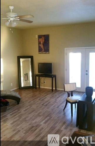 A living room with a wooden floor and a television on a table.