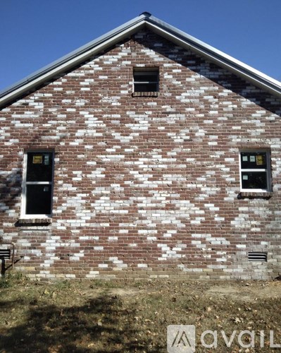 A brick building with two windows and a door.