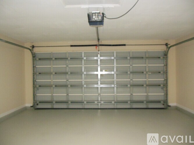 A garage door opener is hanging from the ceiling by a wire.