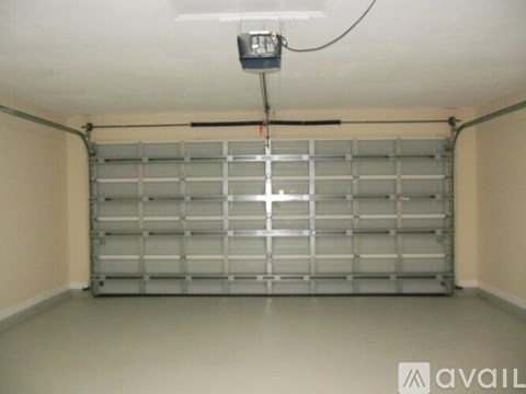 A garage door opener is hanging from the ceiling by a wire.