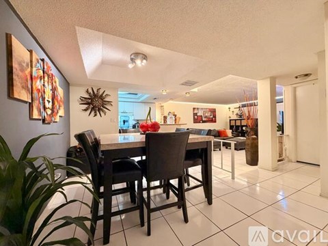 A dining room with a table and chairs.