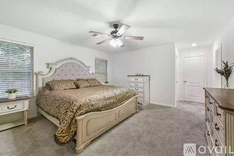 A bedroom with a bed, dresser, and ceiling fan.